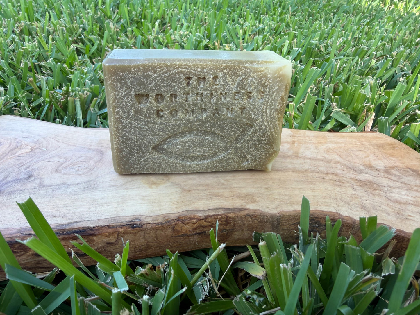 A half-bar of soap sitting on a live-edge wood slab.