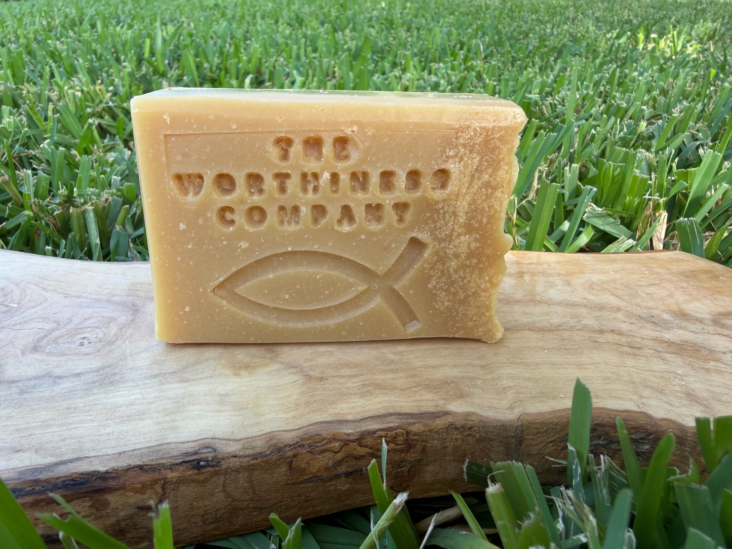One rectangular bar of handmade soap displayed on a wooden slab.