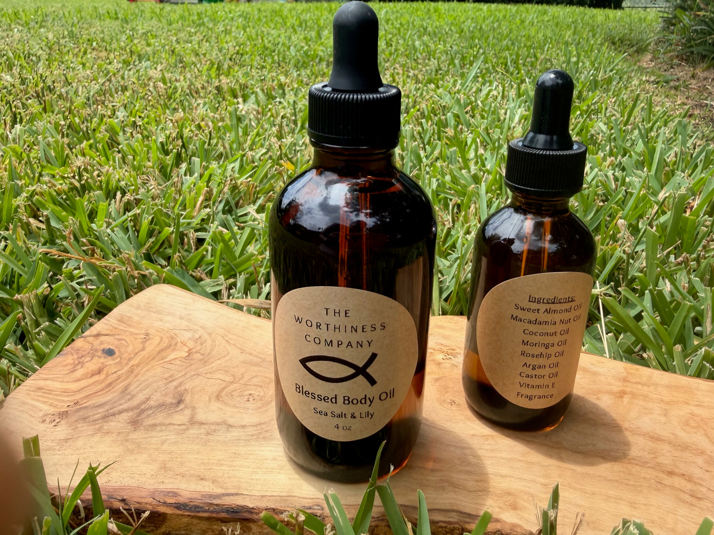 Two amber glass dropper bottles of Blessed Body Oils by The Worthiness Company.