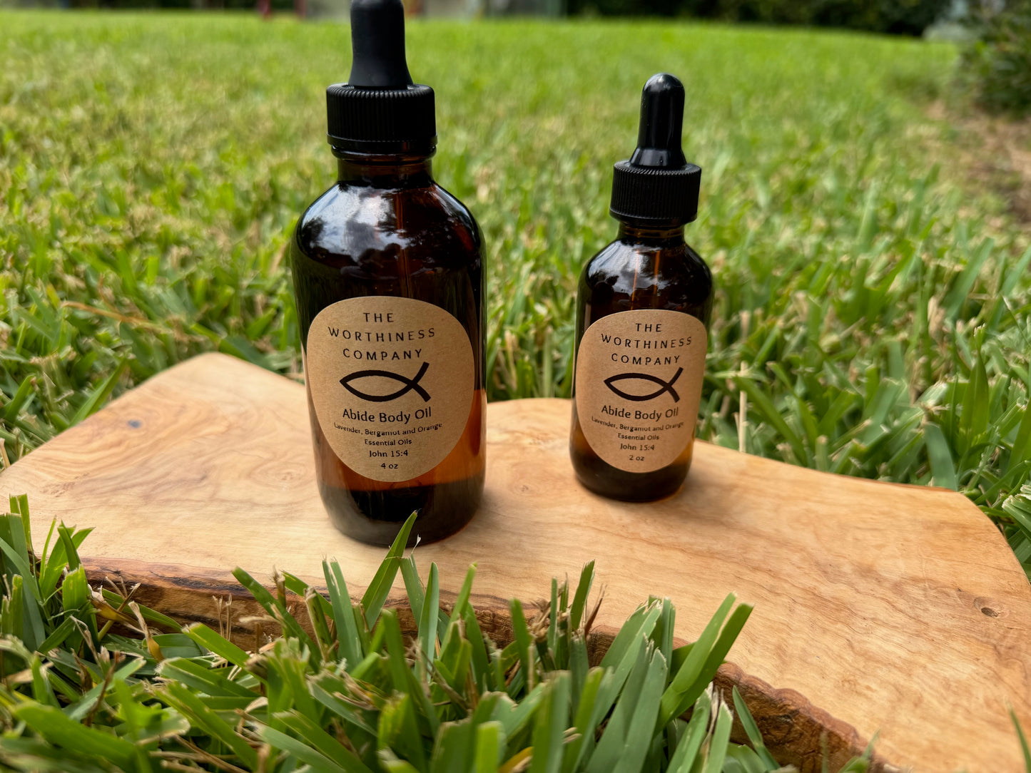 Two amber glass dropper bottles of Abide Premium Body Oils by The Worthiness Company.