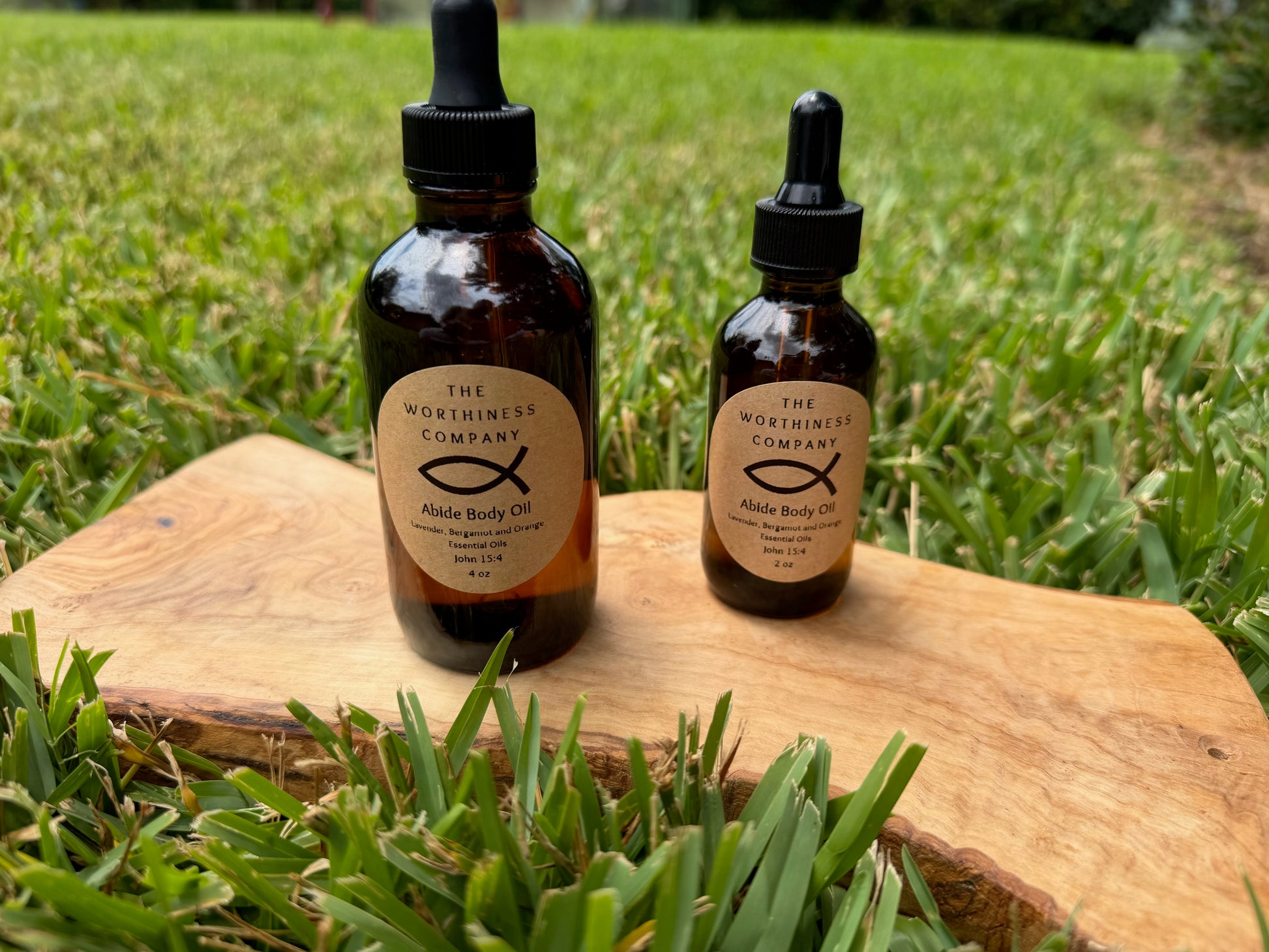 Two amber glass dropper bottles of Abide Premium Body Oils by The Worthiness Company.