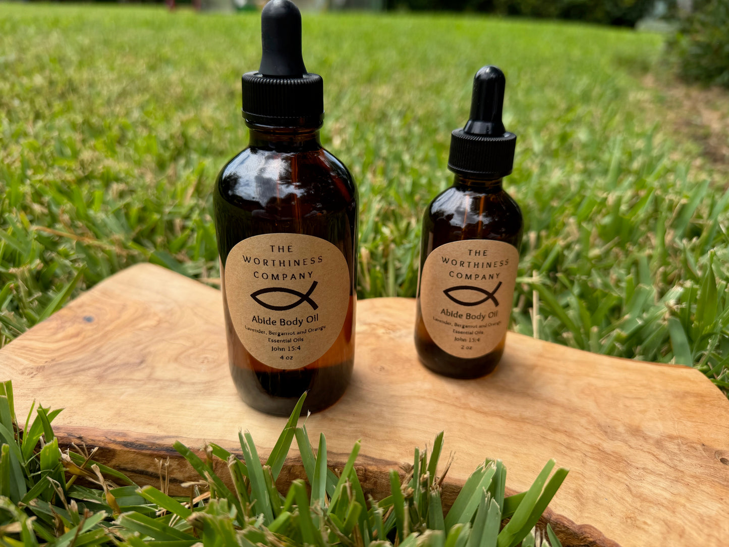 Two amber glass dropper bottles of Abide Premium Body Oils by The Worthiness Company.