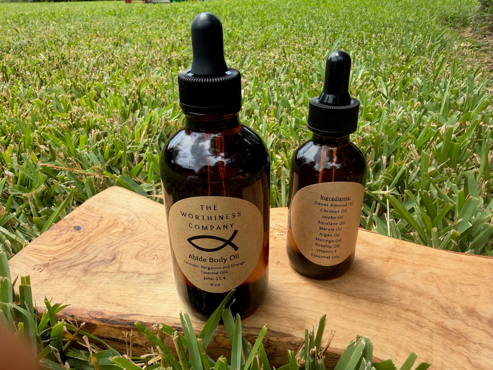 Two amber glass dropper bottles of Abide Premium Body Oils by The Worthiness Company.