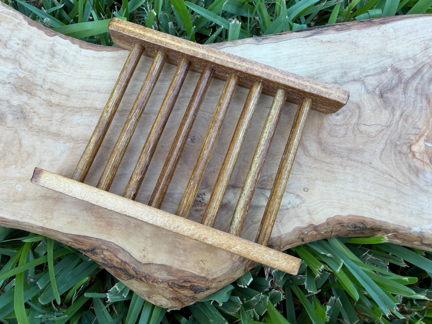 A small wooden slatted soap tray or organizer with two horizontal bars.