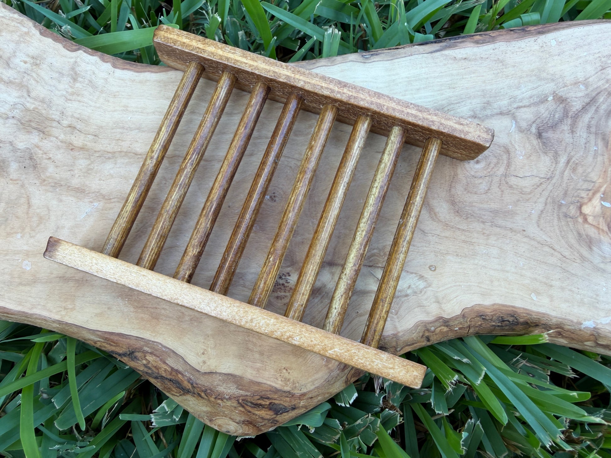 A small wooden slatted soap tray or organizer with two horizontal bars.