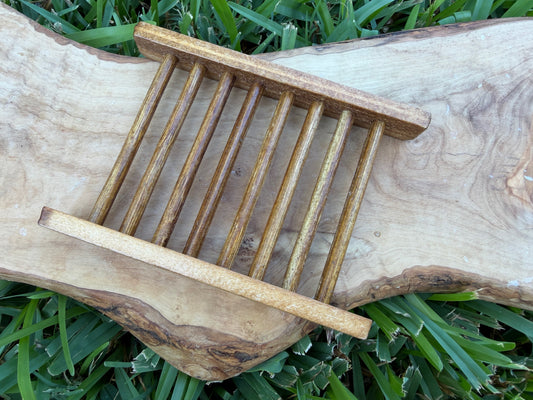 A small wooden slatted soap tray or organizer with two horizontal bars.