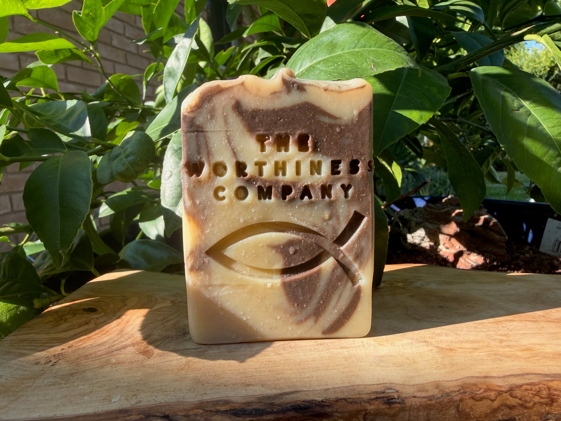 A rectangular handmade soap bar standing upright on a wooden surface.