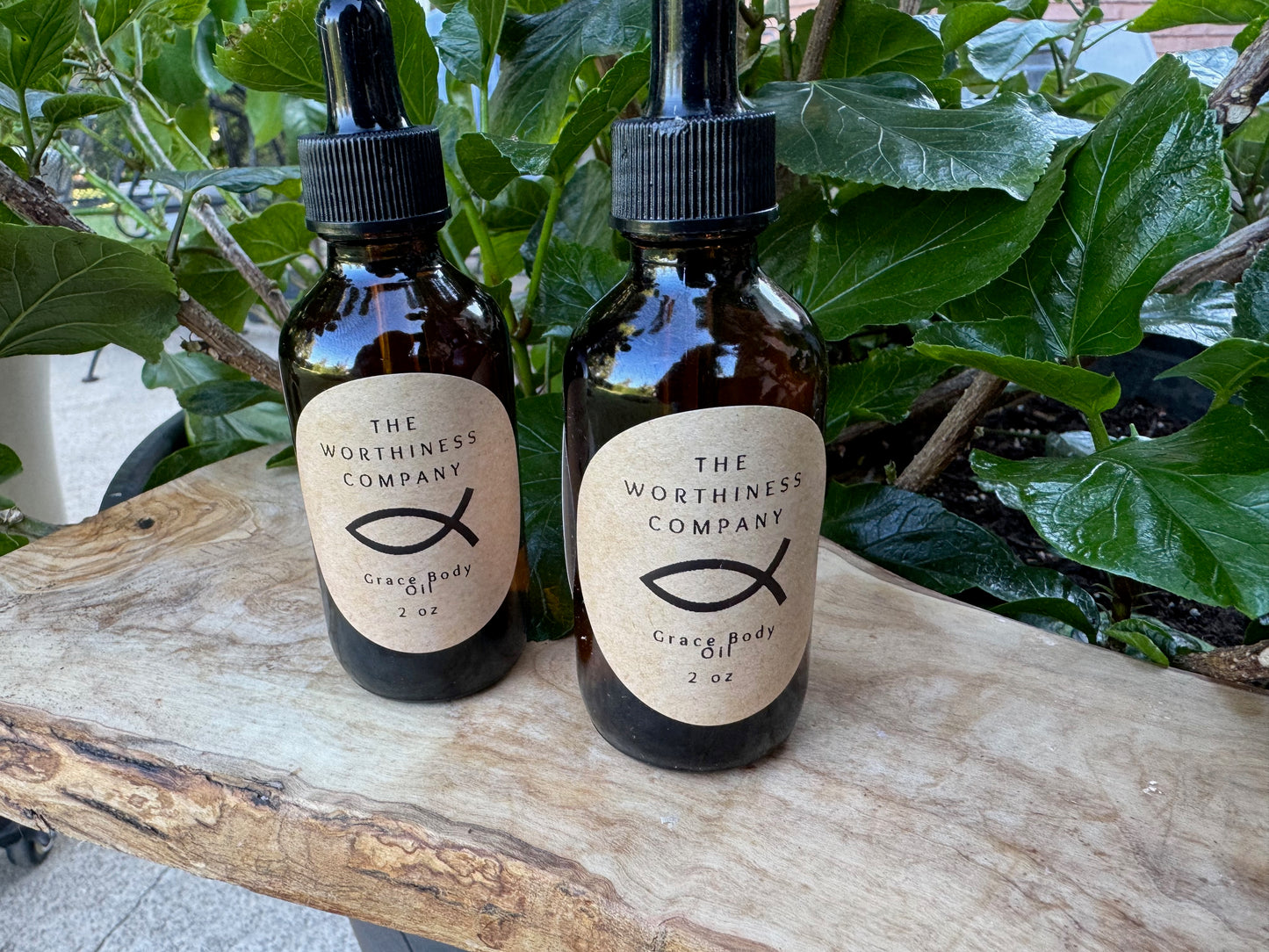 Two amber glass dropper bottles of Grace Body Oils by The Worthiness Company.